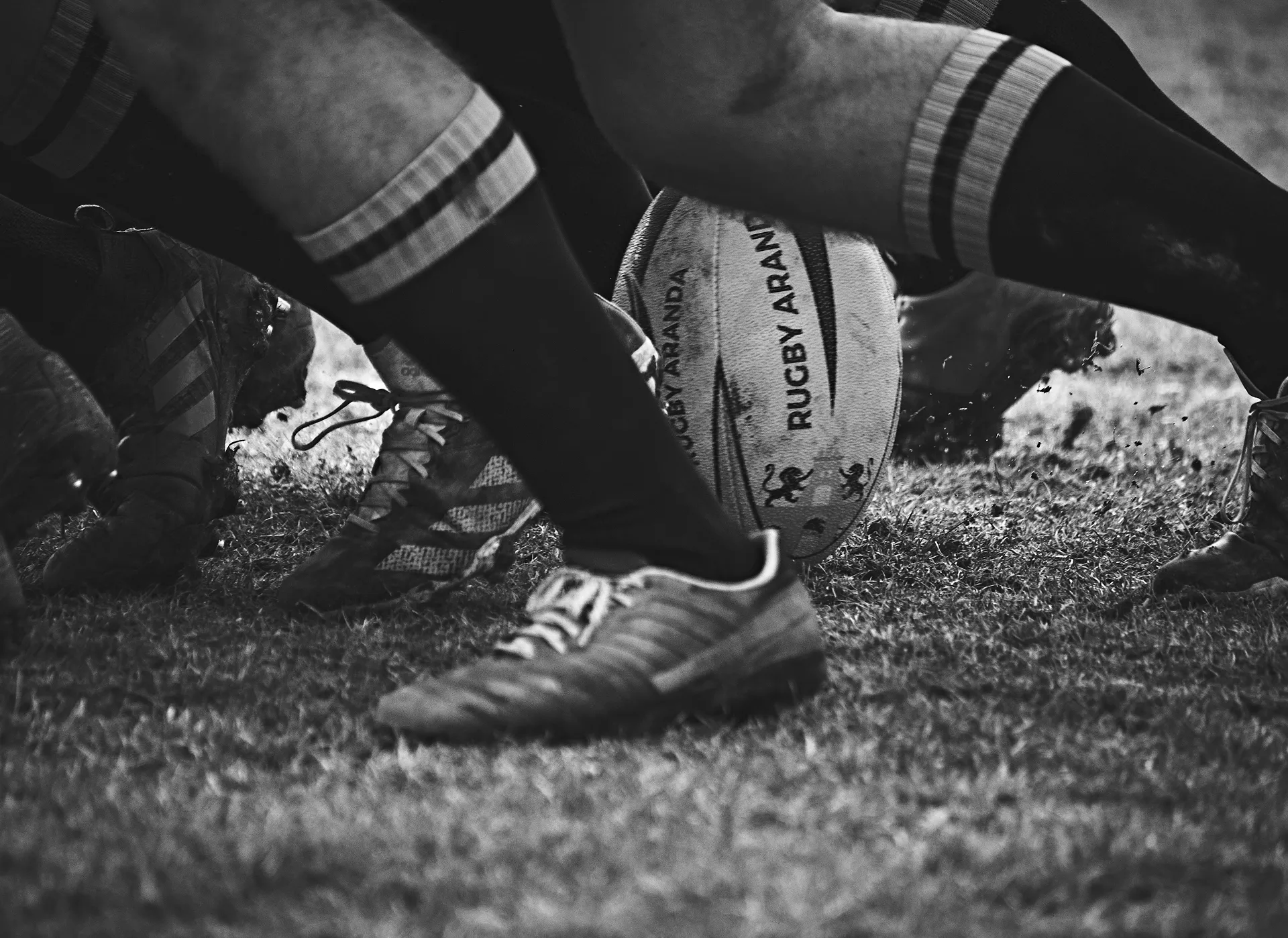 gros plan sur les mollets et les pieds de rugbymen en plein match